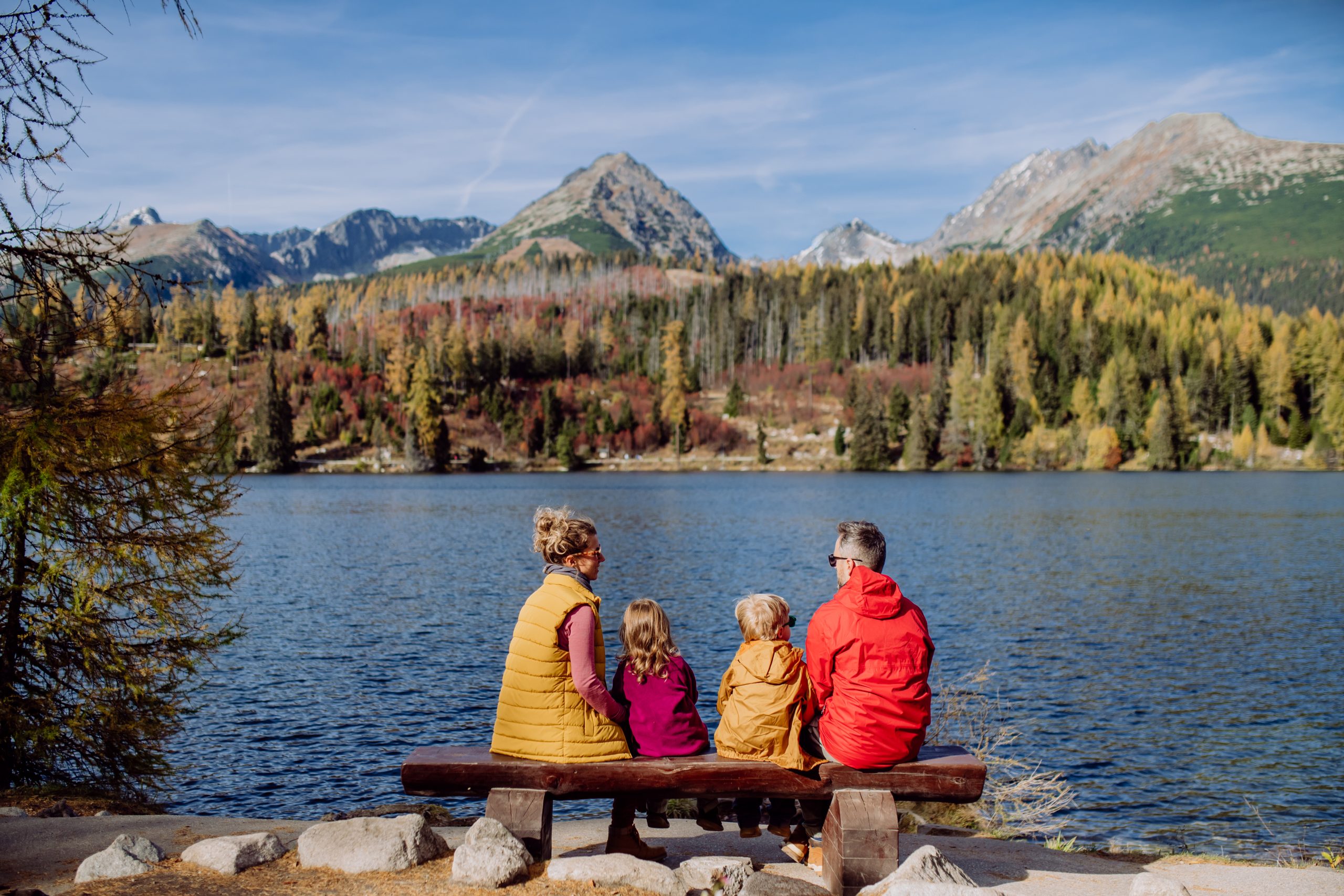 family sitting by mountain reservoir